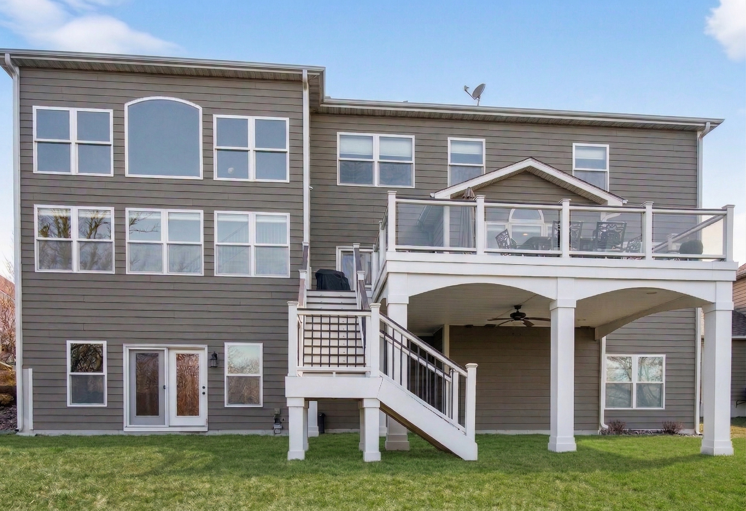 Rear exterior with Trex deck, landscaping, and conservation buffer