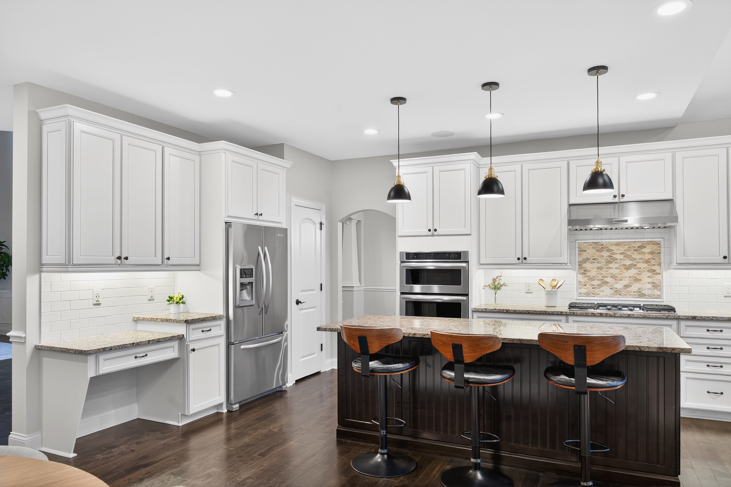 Kitchen island detail with gas cooktop, granite countertops, and pendant lighting