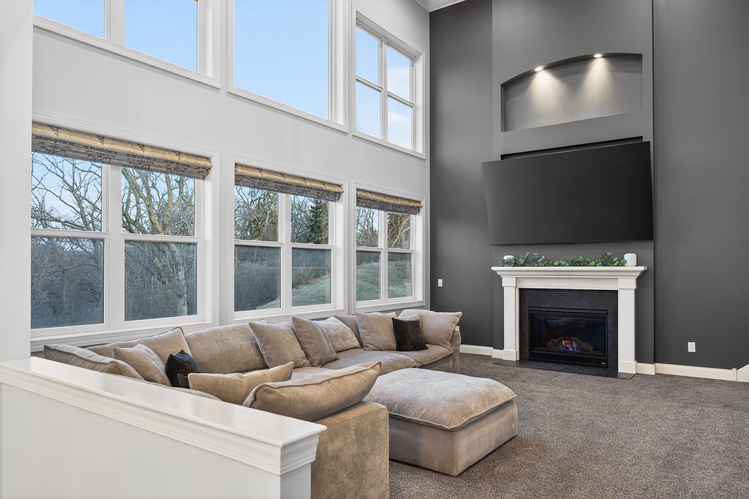 Great room with 24-foot vaulted ceilings, wall of windows overlooking wooded conservation land, gas fireplace